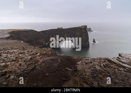 Ein berühmter Felsen namens Dyrholaey liegt in Island in der Nähe der Stadt Vik. Dieser Felsen ist sehr beliebtes Ziel für Fotografen bei jedem Wetter Stockfoto