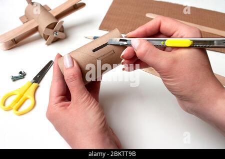 Wie man Flugzeug macht. Handgemachtes Spielzeug, keine Abfälle von Toilettenpapierrolle und Eiswürfeln. Für Kinder und Eltern. Schritt 2, Ausschneiden Loch für Flügel. Stockfoto