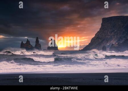 Dramatischer Sonnenuntergang Himmel über Reynisdrangar Meeresstacks und Klippe von Vik, Island Stockfoto