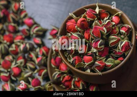 Getrocknete Teerose, Dessertrosen in einer Keramikbecher. Selektiver Fokus. Vintage-Stil. Chinesischer Rosentee. Getrocknete Rosenblüten, die für die Zubereitung von Tee verwendet werden. Stockfoto