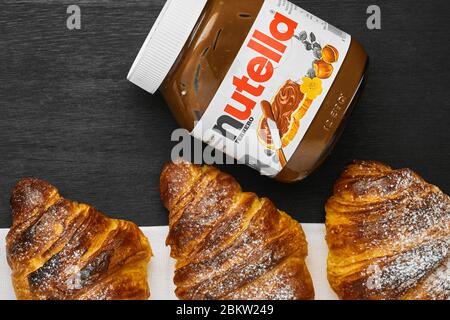 Frisch gebackene Croissants mit Nutella auf schwarzem Hintergrund. Traditionelles französisches oder italienisches Frühstück. Konzept der Werbung. Perfekter Morgen in einem Stockfoto