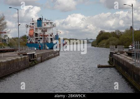 Ein Seeschiff, das Latchford auf dem Manchester-Schiff verlässt Kanal in Warrington mit dem Thelwall Viadukt auf der M6 In der Ferne Stockfoto