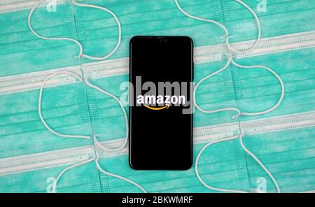 Amazon-Logo auf dem schwarzen Smartphone-Bildschirm, das auf antiviralen Masken platziert wird. Flaches Lay. Konzept für Amazon-Shopping während der COVID-19 Pandemie