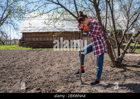 Porträt von fröhlichen jungen Frau mit Gartengeräten im Freien. Stockfoto