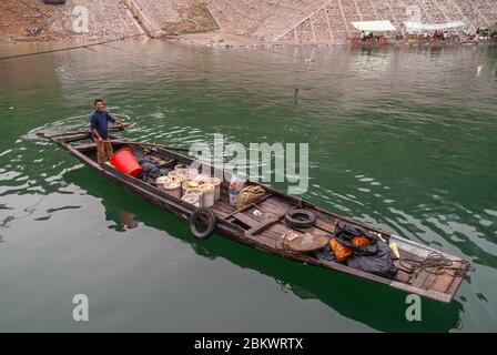 Wuchan, China - 7. Mai 2010: Dicui-Schlucht am Daning-Fluss. Nahaufnahme von lächelnden Bauern oder Fischer auf schwarzen Holzschlaufe mit Eimern und Taschen von fo geladen Stockfoto