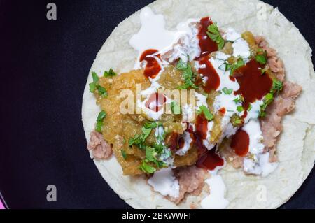 Schweinefleisch spült in grüner Salsa mit gebratenen Bohnen Stockfoto