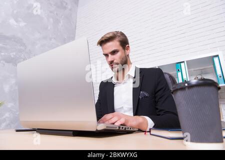 Börsenkonzept. Finanzielle Investitionen Kryptowährung. Finanzdirektorbüro. Konzentrierter Broker. Wirtschaft Rezession und Erholung. Finanzexperte Mann arbeiten mit Laptop trinken Kaffee. Stockfoto