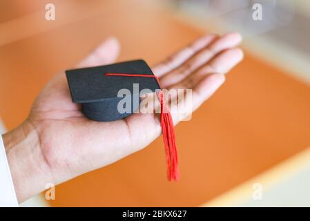 Graduierung Ausbildung Wirtschaft Studienkonzept / Business Mann oder Student mit Abschlusskappe auf der Hand in Tag Graduierung gratulierte den Absolventen in lib Stockfoto