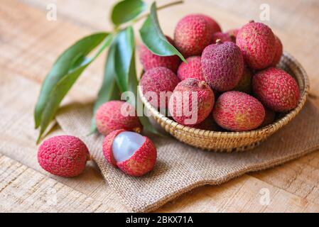 Litschi Scheibe geschält auf Holz / frische Litschi mit grünen Blättern Ernte in Korb von Baum tropische Frucht Sommer in Thailand Stockfoto