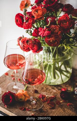 Roséwein in Gläsern und rote Frühlingsblumen Stockfoto