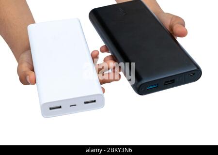 Hände, die das Ladegerät (Power Bank) schwarz und weiß auf weißem Hintergrund halten Stockfoto