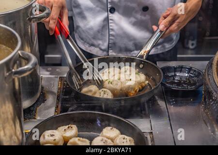 Der Küchenchef kocht in der Küche des Restaurants chinesische gebratene Knödel Stockfoto