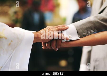 Heiraten, Hände von Braut, Bräutigam und Priester in einer mexikanischen Kirche in mexiko-Stadt Stockfoto