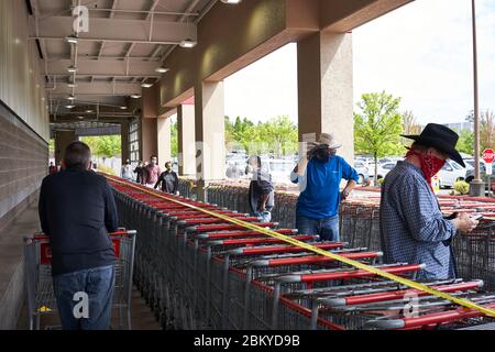 Kunden mit Gesichtsbezügen stehen am Dienstag, den 5. Mai 2020 vor einem Costco-Laden und üben soziale Distanz, da das Geschäft die Belegung begrenzt. Stockfoto