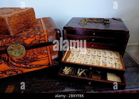 Antikes Mahjong-Set mit teilweise offenen Schubladen, die weiße Fliesen mit chinesischen Schriftzeichen, Theken und Spielsteinen freilegen; mah-jong, mah-jongg. Stockfoto