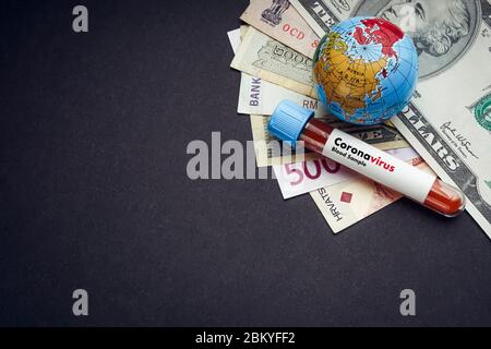CORONAVIRUS Text mit Währungsnoten, Weltkugel und Blutprobe Vakuumröhre auf schwarzem Hintergrund. Covid-19 oder Coronavirus Konzept. Kopierbereich Stockfoto