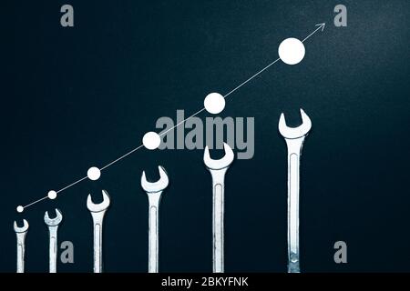 Kreatives Konzept Des Professionellen Wachstums. Verschiedene Größen von Schraubenschlüssel auf EINEM dunklen Hintergrund, Top View Flat Lay mit Infograph Stockfoto