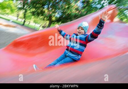 Hannover, Deutschland. Mai 2020. Kian (6) rutscht auf einem Spielplatz, der kurz zuvor veröffentlicht wurde. Die aufgrund der Corona-Pandemie geschlossenen Spielplätze werden am 06.05.2020 zur Freude vieler Kinder wieder eröffnet. Kredit: Julian Stratenschulte/dpa/Alamy Live News Stockfoto