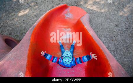 Hannover, Deutschland. Mai 2020. Kian (6) rutscht auf einem Spielplatz, der kurz zuvor veröffentlicht wurde. Die aufgrund der Corona-Pandemie geschlossenen Spielplätze werden am 06.05.2020 zur Freude vieler Kinder wieder eröffnet. Kredit: Julian Stratenschulte/dpa/Alamy Live News Stockfoto