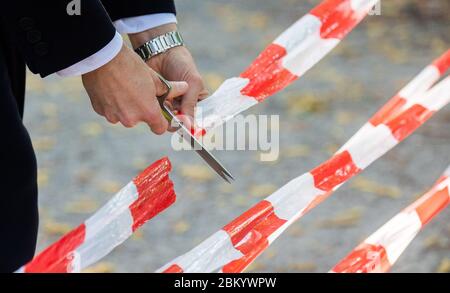 Hannover, Deutschland. Mai 2020. BELIT Onay (Bündnis 90/die Grünen), Oberbürgermeister der Stadt Hannover, schneidet das Absperrband auf einem städtischen Spielplatz mit einer Schere ab. Die aufgrund der Corona-Pandemie geschlossenen Spielplätze werden am 06.05.2020 zur Freude vieler Kinder wieder eröffnet. Kredit: Julian Stratenschulte/dpa/Alamy Live News Stockfoto