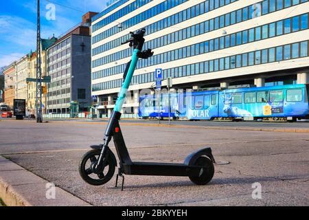 Tier Elektroroller oder E-Scooter in der Stadt Fußgängerzone geparkt, Straßenbahn im Hintergrund. Helsinki, Finnland. Mai 2020. Stockfoto