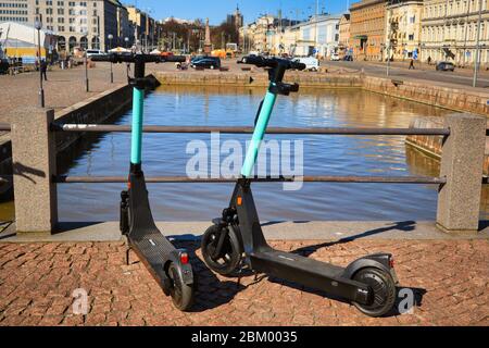 Zwei-Tier-Elektro-Scooter oder E-Scooter in der Fußgängerzone der Stadt in der Nähe des Marktplatzes geparkt. Helsinki, Finnland. 22. April 2020. Stockfoto