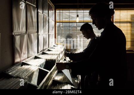 DJs schauen sich am Record Store Day im Palace Vinyl, einem Plattenladen im Crystal Palace, Südlondon, durch Platten Stockfoto