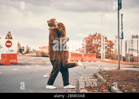 Paar in der Liebe umarmt zusammen auf der Straße in der Stadt. Junge Mädchen und Kerl in Bären-Kostüme. Das Konzept ist nicht wie jeder andere, abheben Stockfoto