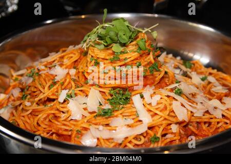 Spaghetti mit Tomatensauce mit Zwiebeln und Sellerie in einer großen Portion in einer großen Schüssel serviert. Stockfoto