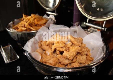 Gebratenes Hähnchen und pommes frites auf einem Büfettablett Stockfoto