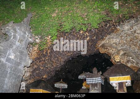 Altäre im Pura Goa Lawah oder bat Cave Temple. Balinesischer Hindu-Tempel, Klungkung, Bali, Indonesien. Einige Fledermäuse fliegen unter einem Felsüberhang. Kolonie von Fledermäusen ha Stockfoto