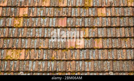 Hintergrund alter, traditioneller moosroter Dachziegel Stockfoto