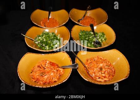 Beilage im koreanischen Stil, Kimchi und grüne Zwiebel auf einem kleinen Teller. Stockfoto