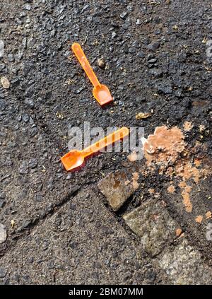 Weggeworfene Eislöffel auf dem Bürgersteig in Berlin Stockfoto