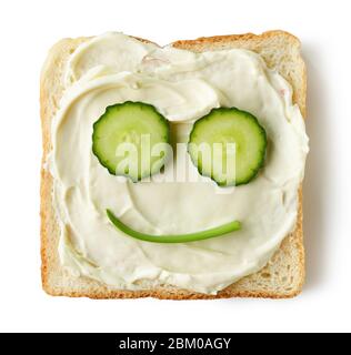 Geröstetes Brot mit Frischkäse und Gurken Gesicht isoliert auf weißem Hintergrund, Draufsicht Stockfoto