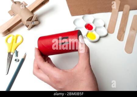 Wie man Flugzeug macht. Handgemachtes Spielzeug, keine Abfälle von Toilettenpapierrolle und Eiswürfeln. Für Kinder und Eltern. Schritt 7, rot lackiert großes Detail. Stockfoto