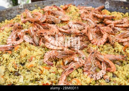 Meeresfrüchte Paella in einer großen Pfanne Wok gekocht, Street Food Festival. Mexikanische Fiesta Nationalgericht Spezialität. Live-Kochstation. Frisches Essen Buffet Frühstück Stockfoto