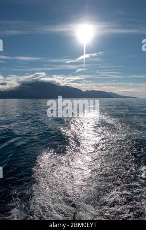 Blick auf eine helle untergehende Sonne über Skjálfandi Bucht, Husavik, Island. Stockfoto