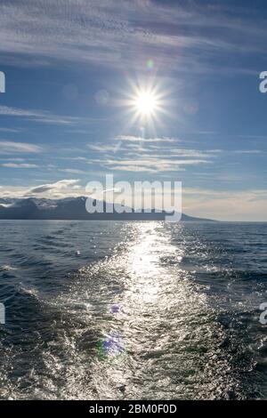 Blick auf eine helle untergehende Sonne über Skjálfandi Bucht, Husavik, Island. Stockfoto