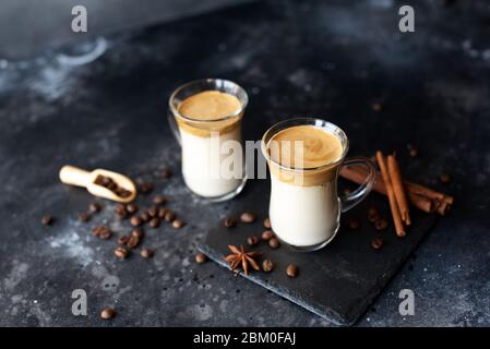 Zwei Glasbecher mit Dalgona schaumig Kaffee Trend koreanisch trinken Latte Espresso mit Kaffeeschaum auf schwarzem Hintergrund. Stockfoto
