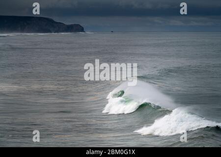 Malerischer Blick auf die Küste entlang des Amado-Strandes (Praia do Amado) mit großen Wellen während eines Sturms an der Algarve, Portugal Stockfoto