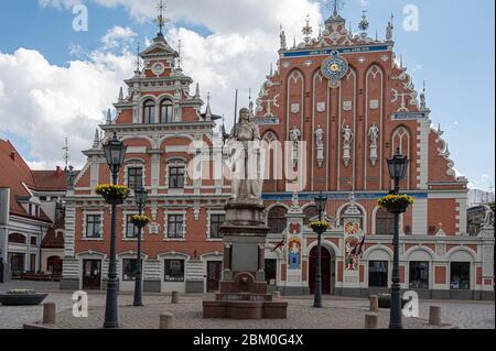Tagsüber sehen Sie das berühmte Haus der Schwarzen Köpfe und die Roland-Statue auf dem Rathausplatz in Riga in der Altstadt von Riga. Stockfoto