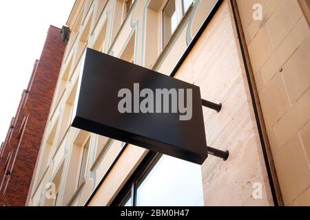 Namensschild des Gebäudes. Leeres Namensschild des Hauses. Leeres Feld für Nummer, Text oder Name des Shops an der Ziegelwand. Seitenansicht von unten. Schwarz Stockfoto