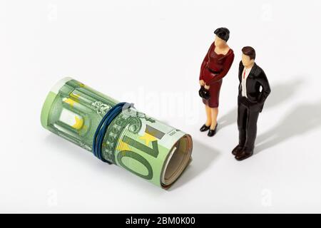 Menschliche Darstellung eines Paares, das eine Rolle Geld anschaut. Finanz-, Investitions- oder Sparkonzept Stockfoto