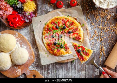 Von oben unkenntlich Frau mit einem Stück Pizza. Horizontale drinnen geschossen. Stockfoto