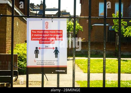 Regierungsplakat erinnert die Bevölkerung an die sozialen Distanzierungsmaßnahmen in Hackney, London, April 2020 Stockfoto