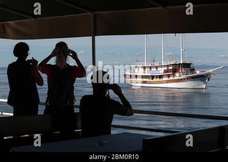 Silhouetten von Touristen, die ein Touristenschiff fotografieren Stockfoto