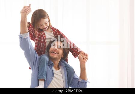 Fröhlicher Vater und kleines Mädchen, die Spaß zu Hause Stockfoto