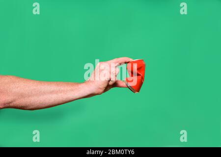 Hand Zinn Zinn Zinn auf grünem Hintergrund zu zerquetschen Stockfoto