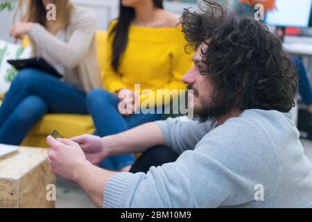 Multirassischen junge kreative Menschen in modernen Büro. Sind eine Gruppe von jungen Geschäftsleuten zusammen mit Laptop, Tablet-PC, Smartphone, Notebook. Su Stockfoto
